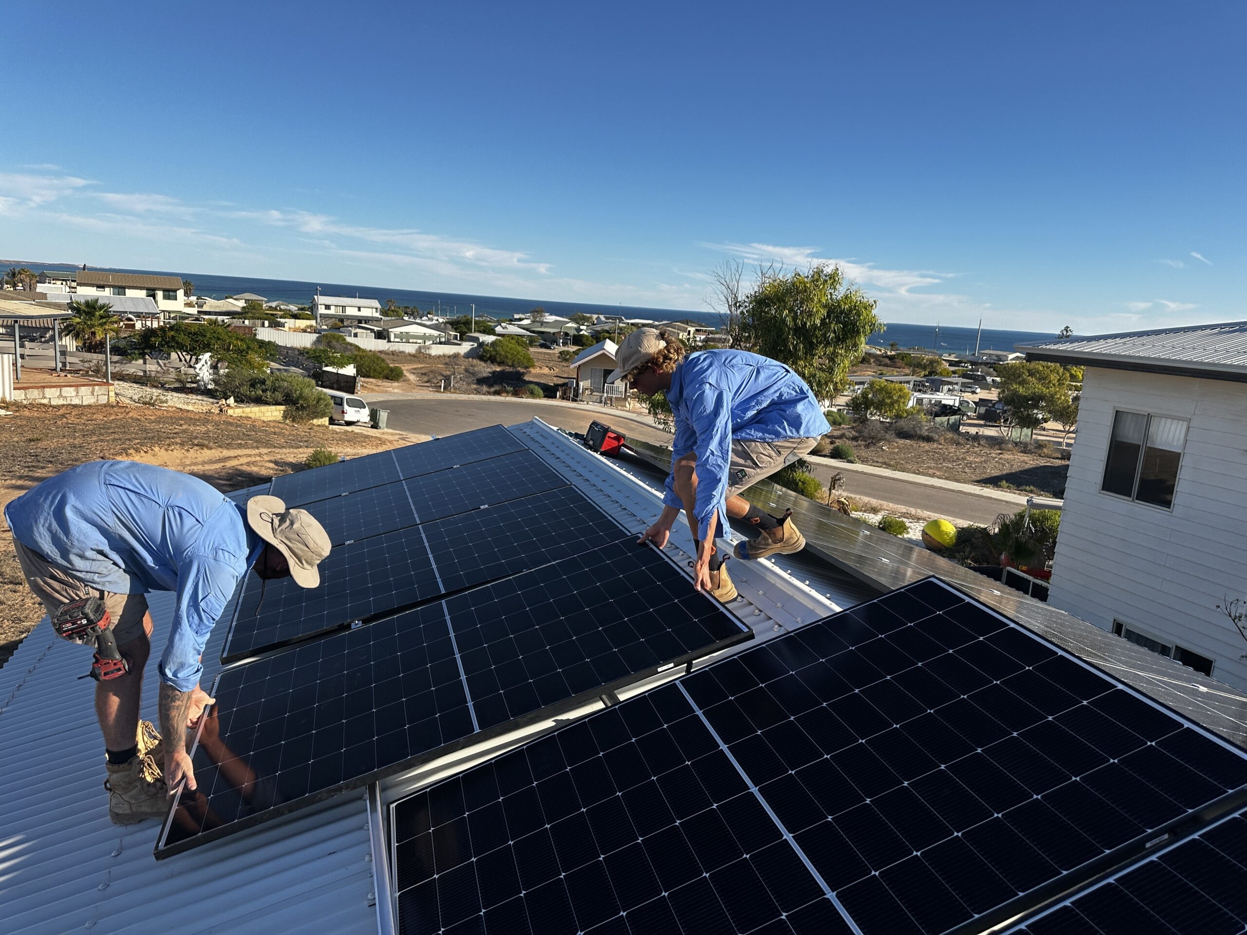 2 of the electric cool geraldton technicians adding solar panel to a roof of a house in geraldton